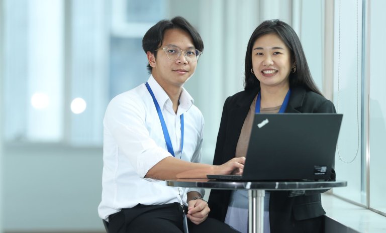 A man and a woman in front of a laptop