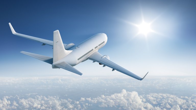 A plane flying over the clouds in a blue sky