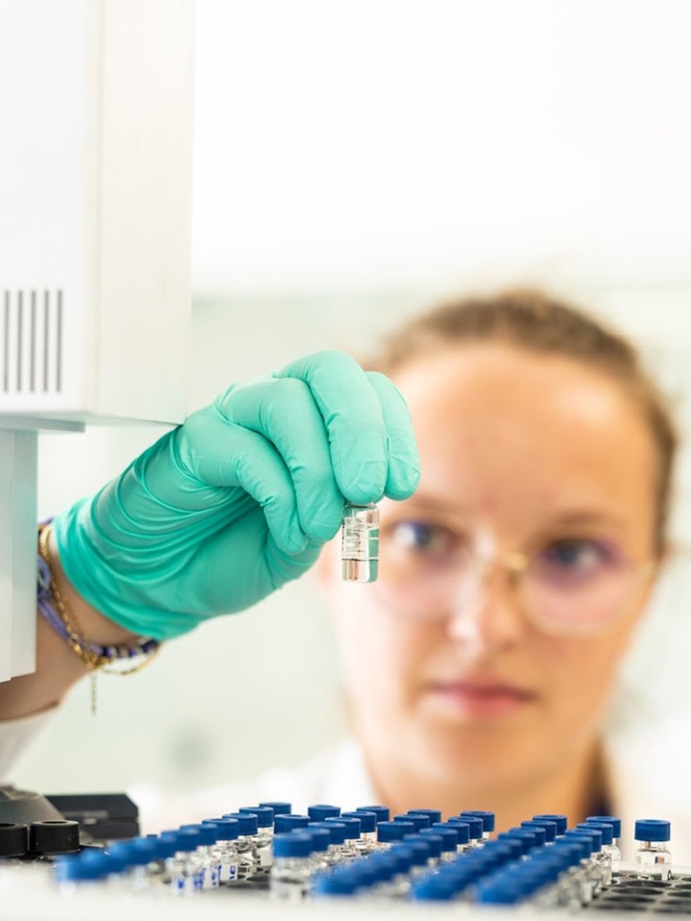 Two scientists from Technip Energies, one of them is holding and inspecting a flask