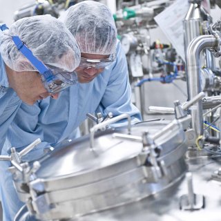 Image de la page Industries qui montre deux personnes travaillant dans une unité pharmaceutique réalisée par Technip Energies.