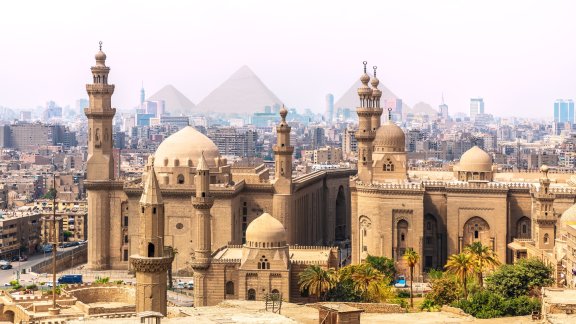 Image of buildings in Cairo with pyramids in the background